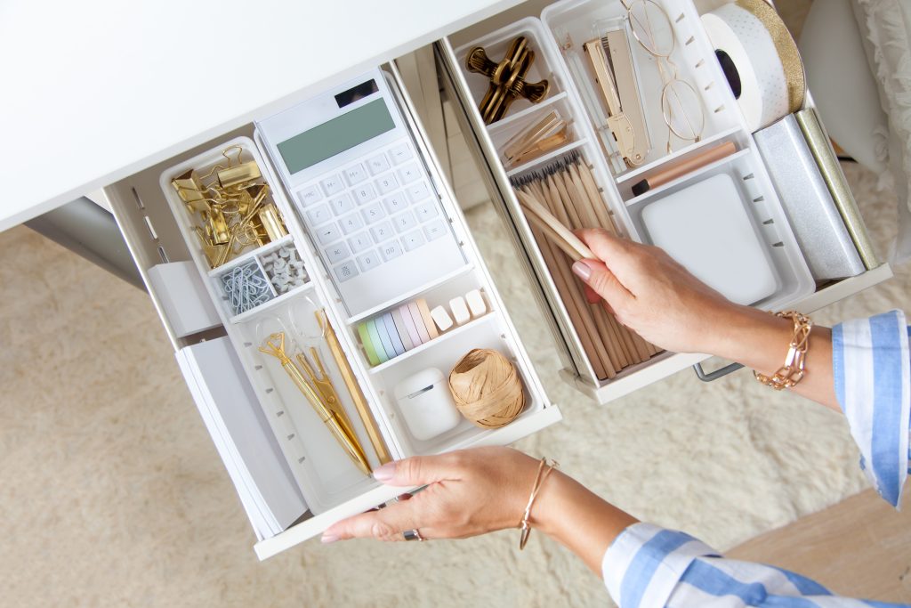 An open desk drawer with well-organized supplies inside.