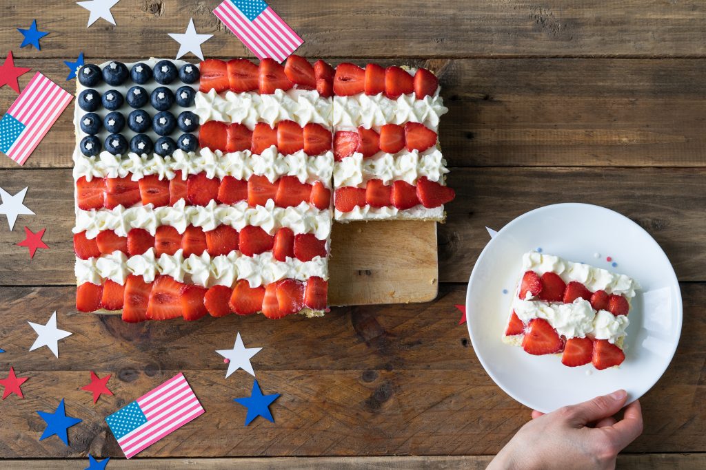 A cake decorated with strawberries and blueberries to look like the American Flag.