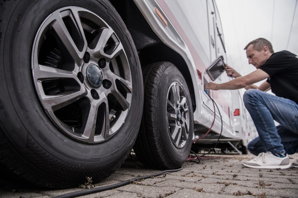 A man checking the tires on an RV.