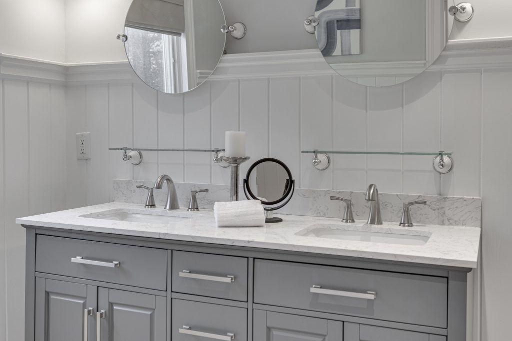 A gray, modern-style bathroom with silver hardware.