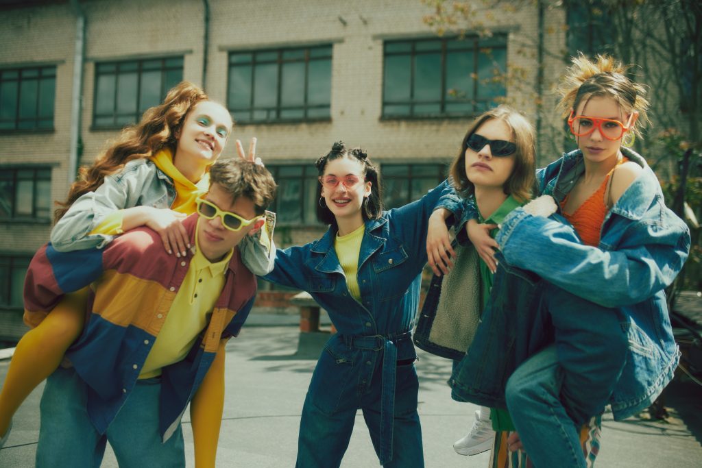 A group of young adults wearing vintage clothes, likely from the early 1990s.