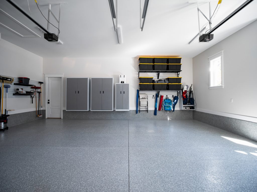 A clean garage with storage cabinets and shelves.