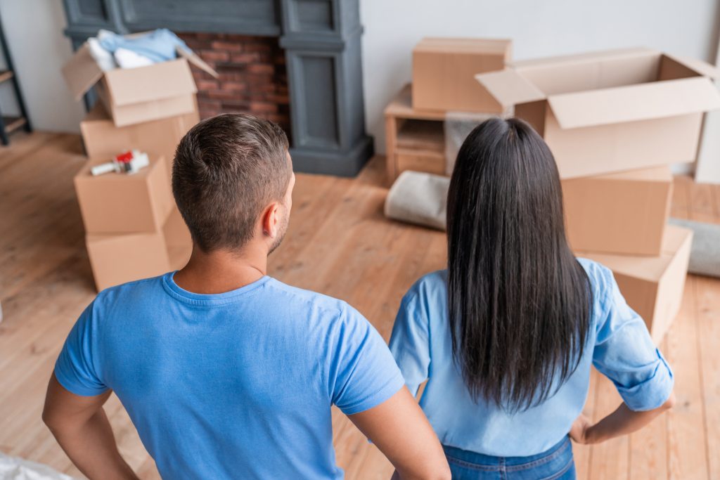 Couple looking at stacks of moving boxes.