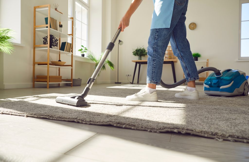 A person vacuuming in a clean living room.