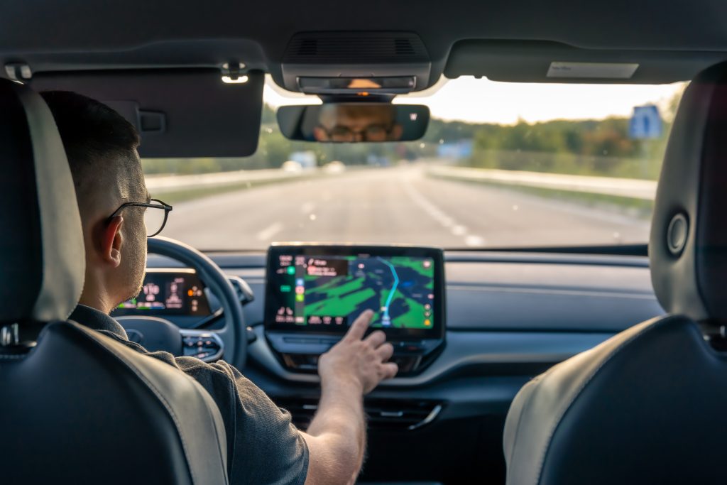 Man using a GPS navigator while driving.